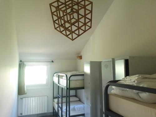 a dorm room with bunk beds and a chandelier at Langre Wayve House in Langre