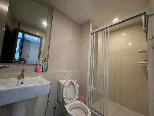 a bathroom with a toilet and a sink and a shower at The Base Central Pattaya by Adam in Pattaya