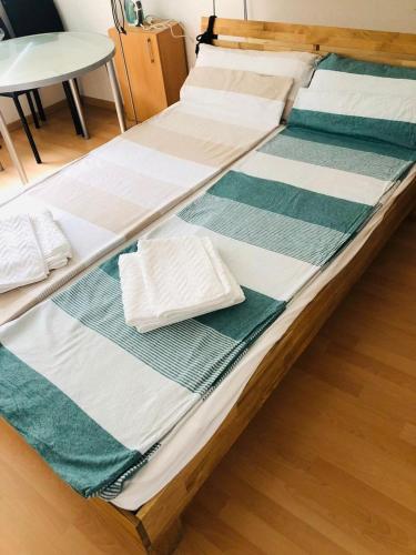 a large wooden bed with green and white blankets at Appartement München Zentrum in Munich