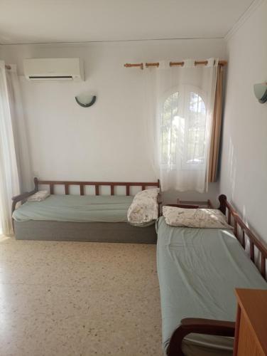 two beds in a room with a window at Apartamento Rey-Piscina in Denia
