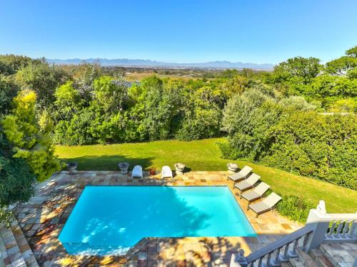 an overhead view of a swimming pool in a yard with lounge chairs at Devonport House - Constantia in Cape Town