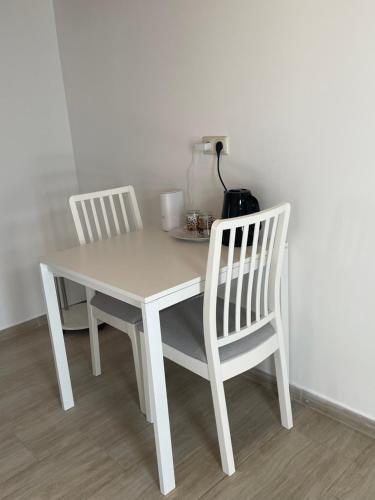a white table with two chairs and a blender at Kleine aber feies Zimmer in Falkenberg