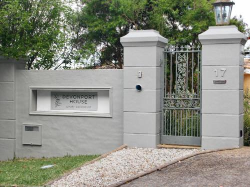 a gate to a house with a sign on it at Devonport House - Constantia in Cape Town