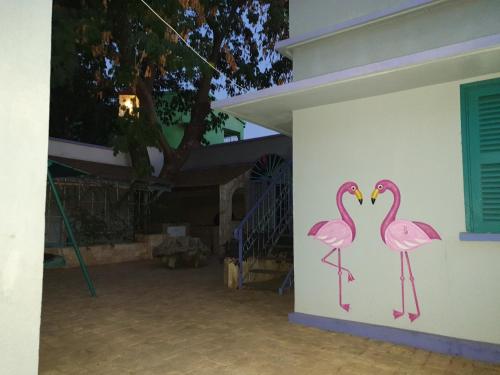 two pink flamingos painted on the side of a building at Flamingo résidence in Toliara