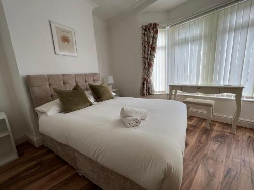 a bedroom with a large bed with white sheets at Liverpool Ivy House - 4 Bedrooms in Liverpool