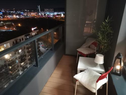 a balcony with a view of a city at night at MustSEA Gdańsk Apartments with underground parking in Gdańsk