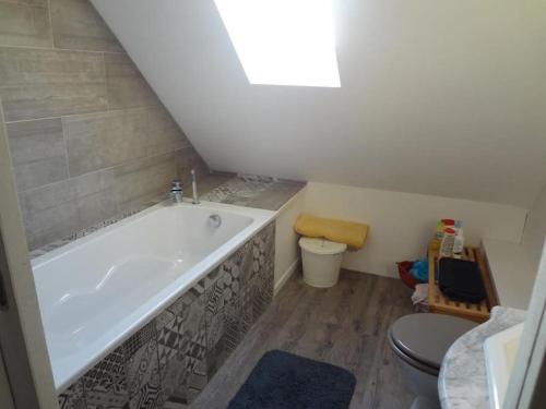 une salle de bain avec baignoire et toilettes dans l'établissement Villa calme et lumineuse à 500m de la plage, à Trévou-Tréguignec