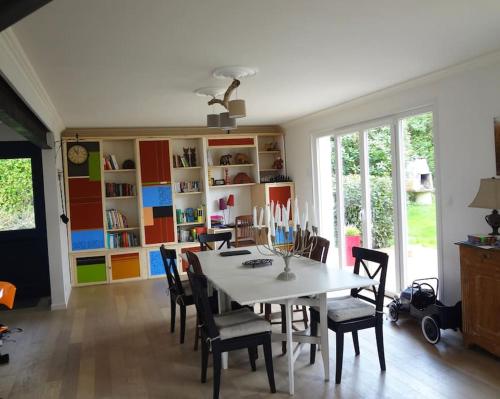 une salle à manger avec une table et des chaises blanches dans l'établissement Villa calme et lumineuse à 500m de la plage, à Trévou-Tréguignec