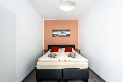 um quarto com uma cama com almofadas vermelhas em Newly renovated, quiet street central apartment with two bedrooms em Viena