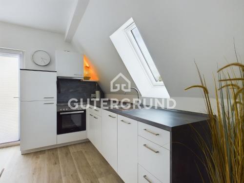 una cocina con armarios blancos y un reloj en la pared en Studio-Apartment "Charlotte", en Westerstede