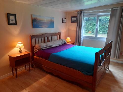 Un dormitorio con una cama grande y una ventana en gite la bretonne, en Plouha