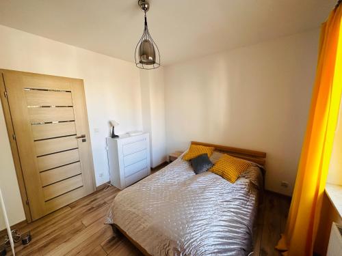 1 dormitorio con 1 cama y luz colgante en Apartament Neustettin-Polna Szczecinek, en Szczecinek