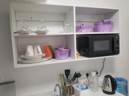 encimera de cocina con microondas y algunos platos en JVhomestudios-Ndemi gardens apartments en Nairobi