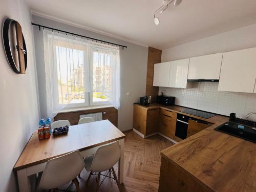 kuchnia ze stołem i krzesłami oraz oknem w obiekcie Apartament Neustettin-Polna Szczecinek w Szczecinku