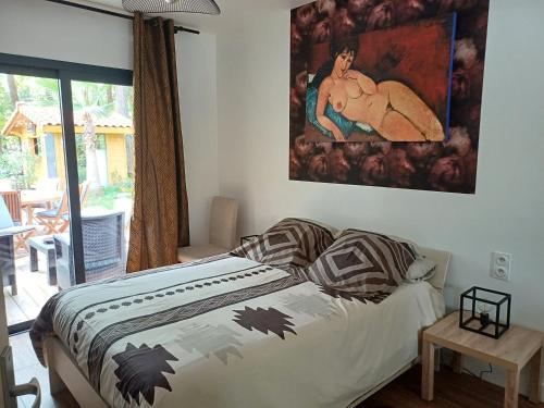 Magnifique villa avec piscine في بيسكاروس: غرفة نوم بسرير مع لوحة على الحائط