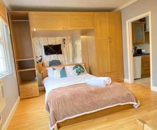 Schlafzimmer mit einem großen Bett und Holzschränken in der Unterkunft Stunning 1-Bed Apartment in London in London