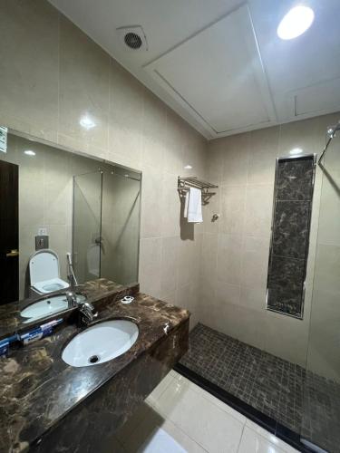 a bathroom with a sink and a shower at ALJAWHARA ALZARQAA FOR SERVICED APARTMENTS Est 2 in Rabigh