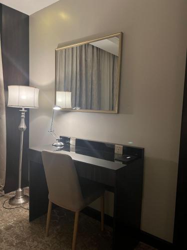 a bathroom with a desk with a mirror and a lamp at ALJAWHARA ALZARQAA FOR SERVICED APARTMENTS Est 2 in Rabigh