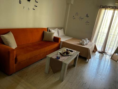 a living room with an orange couch and a table at Central House Karistos in Karistos