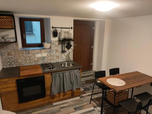 una cucina con lavandino e tavolo con sedie di casa vacanze Villanova - 4 posti letto a Villanova