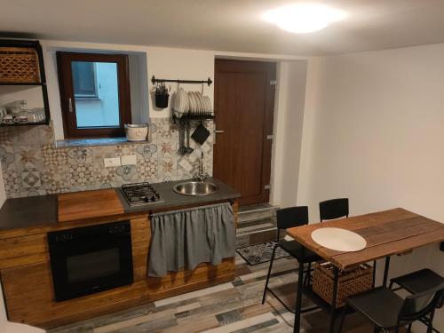 a kitchen with a sink and a table with chairs at casa vacanze Villanova - 4 posti letto in Villanova