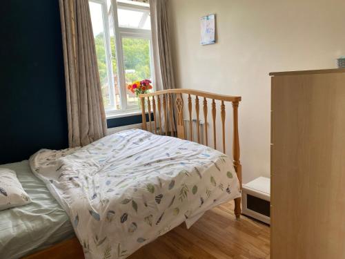 a small bedroom with a crib and a window at Private Lovely double bedroom in High Wycombe