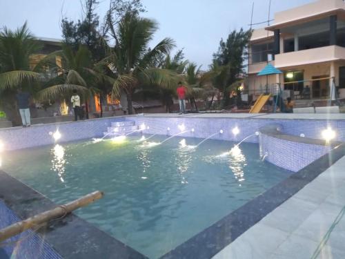 a large swimming pool with lights in a resort at Arya Beach resort in Mandarmoni