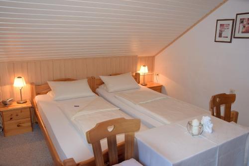 2 Betten in einem Zimmer mit 2 Tischen und 2 Lampen in der Unterkunft Hotel Pension Schwaiger in Sankt Margarethen im Lungau
