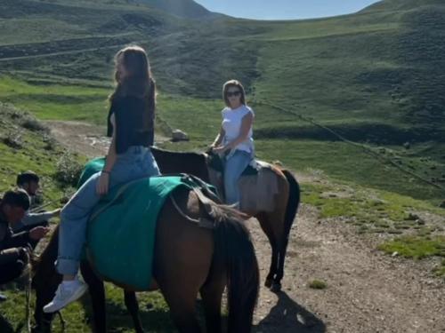 two girls riding on horses on a hill at Xinaliq İzzet's Riverside Home Stay in Xınalıq