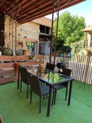 a glass table and chairs on a patio at Adorable Guest House « bienvenue chez vous ! » in Bordères-sur-lʼÉchez