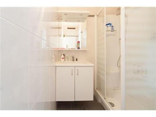 uma casa de banho branca com um lavatório e um chuveiro em Vakantie verblijf Oostende em Oostende