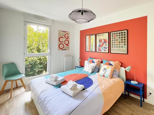 ein Schlafzimmer mit einem großen Bett und einer orangefarbenen Wand in der Unterkunft Le 24 Nautic, Appartement douillet Bassin olympique Disneyland & Paris avec parking in Vaires-sur-Marne
