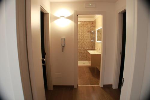 um corredor com uma casa de banho com um lavatório e uma luz em Suite Rosso & Nero em Lecce