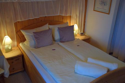 a bedroom with a large bed with white sheets and pillows at Hotel Pension Schwaiger in Sankt Margarethen im Lungau
