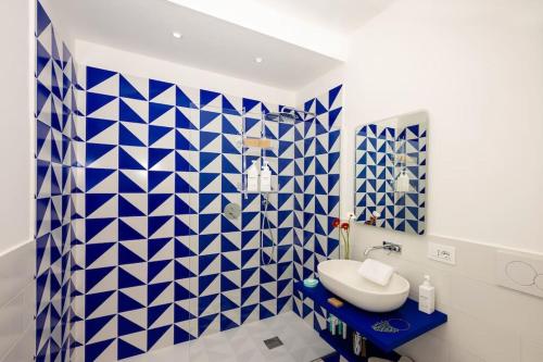 a bathroom with blue and white tiled walls and a sink at Casa Luma, il sogno di Positano! in Positano