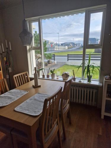 a dining room with a table and a large window at Sól - S12 guesthouse in Keflavík