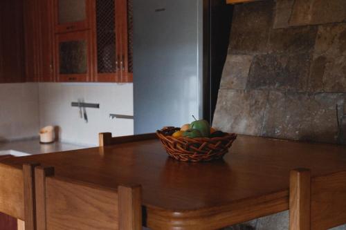 un plato de fruta en una mesa de madera en la cocina en Дом с видом на старую крепость, en Kamianets-Podilskyi