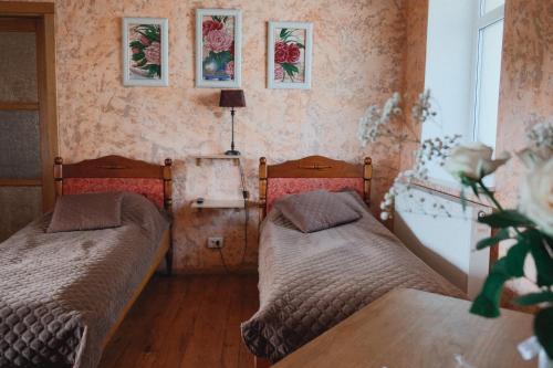 2 camas en una habitación pequeña con flores en la pared en Дом с видом на старую крепость, en Kamianets-Podilskyi