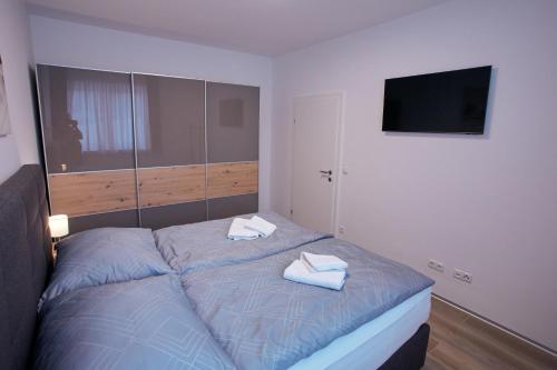 a bedroom with a bed with two towels on it at Deluxe Apartment Leibnitz in Leibnitz