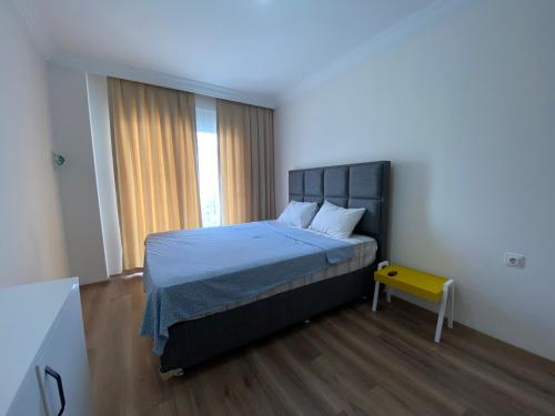 IN+ RESIDENCE في ألانيا: غرفة نوم بسرير كبير ومقعد اصفر