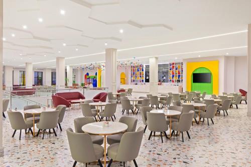 a cafeteria with tables and chairs in a building at Pickalbatros Jungle Aqua Park - Neverland Hurghada in Hurghada
