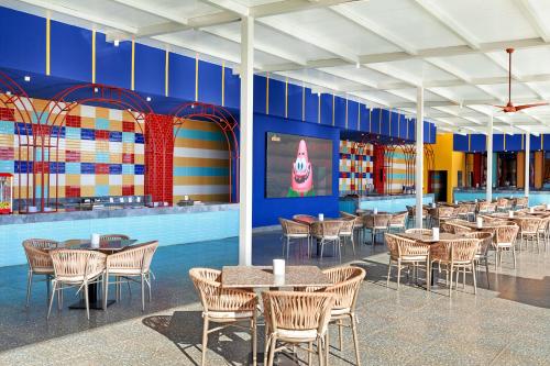 a dining area with tables and chairs in a building at Pickalbatros Jungle Aqua Park - Neverland Hurghada in Hurghada