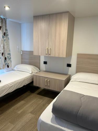 1 dormitorio con 2 camas y armario en Villaggio Turistico Maderno, en Toscolano Maderno