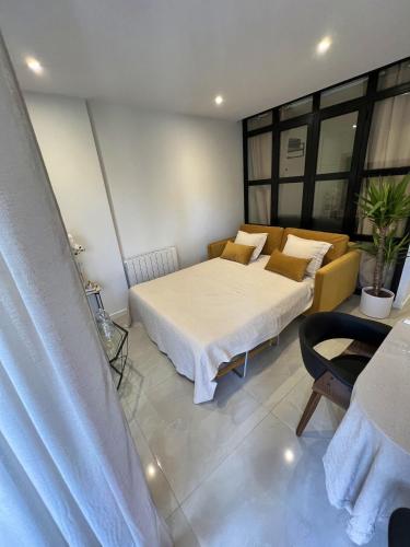 une chambre avec un lit et un canapé dans l'établissement Appartement confortable à Neuilly-sur-Seine 43 m² avec balcon, à Neuilly-sur-Seine