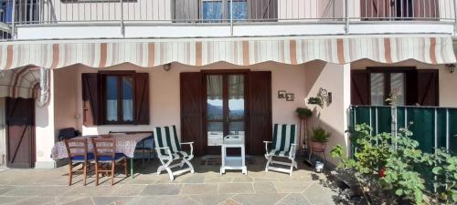 ein Haus mit einem Tisch und Stühlen auf einer Terrasse in der Unterkunft Casa Vacanze Le tre Sorelle in Torre Pellice