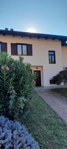 a house with a brick driveway and flowers in front of it at Casa Vacanze Le tre Sorelle in Torre Pellice