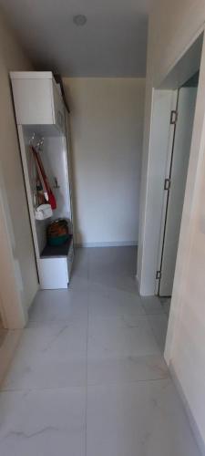 um corredor vazio com um frigorífico num quarto em COSY APPARTEMENT near the sea em Kargicak