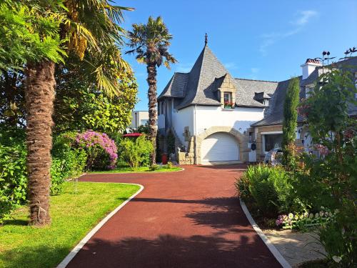 a house with a palm tree and a driveway at LA TOURELLE in Morlaix