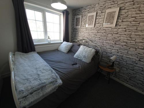 a bedroom with a bed and a stone wall at Little House On The Hill Conisbrough in Conisbrough