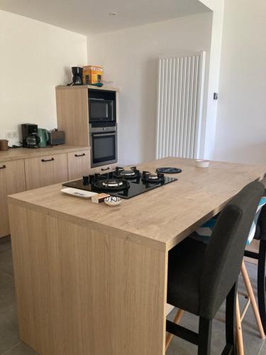 a kitchen with a island with a stove top oven at Le Cysphée chez Christelle in Sallertaine